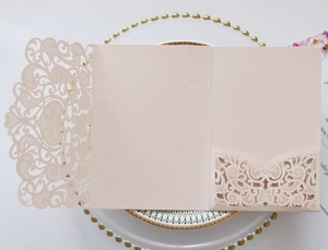 Laser-cut blush pink wedding invitation pocket with intricate floral hollow pattern