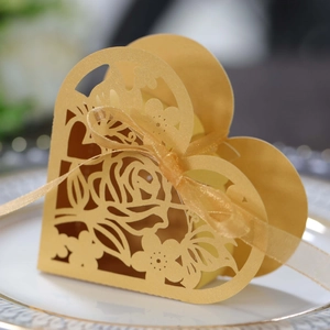 Détail de la boîte à dragées cœur dorée découpée au laser avec motifs roses et ruban