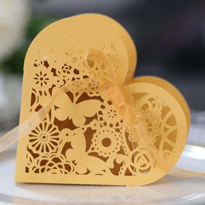 Macro shot of laser-cut heart candy box with elegant butterfly lace patterns and ribbon