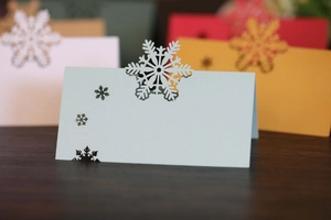 Gros plan sur un marque-place bleu avec flocon de neige découpé au laser et texture perle