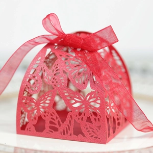 Close-up of laser-cut butterfly patterns on red wedding gift box with ribbon