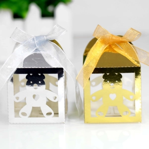 Macro detail of gold and silver hollow bear gift boxes with glossy finish and silk ribbons