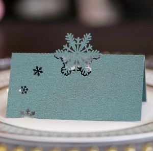 Détail de marque-place découpé au laser avec flocon de neige en papier vert foncé mat