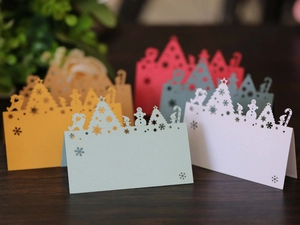 Macro shot of laser-cut Christmas place cards with snowflake and snowman patterns