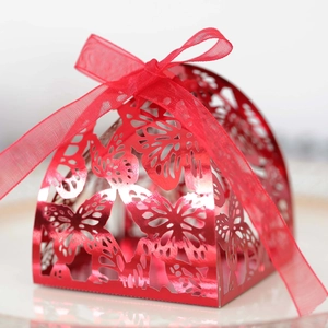 Macro detail of red laser-cut butterfly candy box with metallic finish and silk ribbon