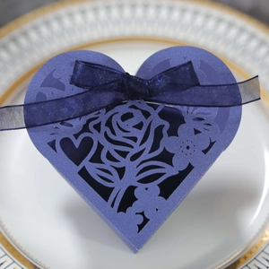 Détail boîte cadeau cœur violette découpée au laser avec motifs roses et nœud ruban