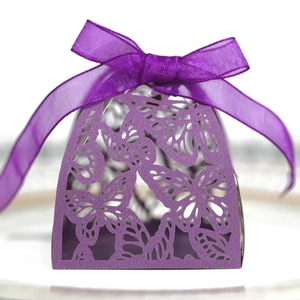 Close-up of laser-cut butterfly hollow gift box with elegant purple ribbon bow