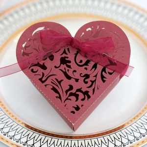Vista macro della scatola a cuore bordeaux con intaglio laser e fiocco in nastro
