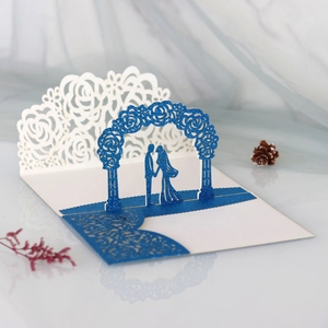 Detail showing 3D laser cut blue glitter wedding invitation with floral arch and couple
