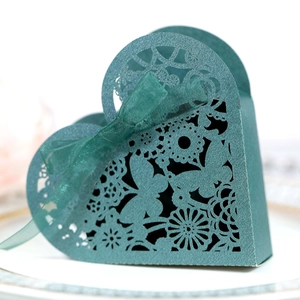 Macro detail of laser-cut butterfly heart gift box in dark green with organza ribbon