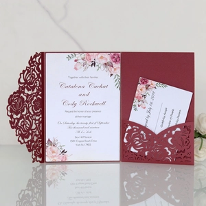 Macro view of burgundy laser-cut floral wedding invitation set with floral card details