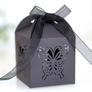 Detail of elegant black laser-cut butterfly gift box with ribbon for wedding favors