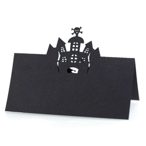 Macro shot of laser-cut Halloween place card featuring a haunted castle and skull design
