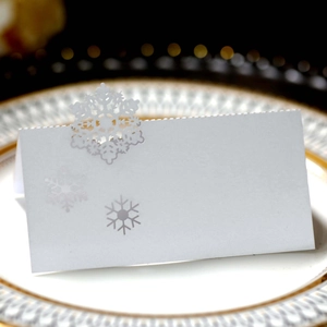 Detail of white laser-cut snowflake place card for wedding and Christmas table setting
