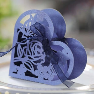 Détail boîte cadeau coeur bleue avec découpe laser, motifs roses et ruban élégant