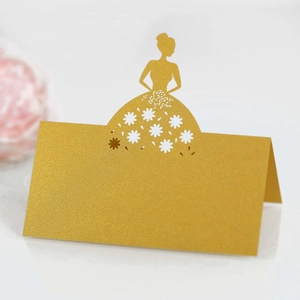 Detail of laser-cut gold place card with bride silhouette and floral hollow design
