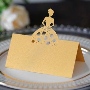 Detail of laser-cut gold place card with elegant girl silhouette on a white dining plate