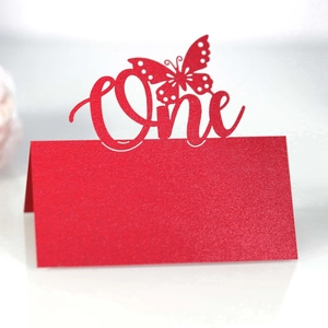 Macro view of a red glitter table card with laser-cut butterfly and One text