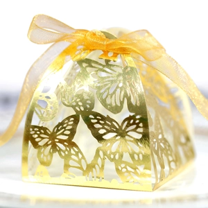 Detailed close-up of golden butterfly laser-cut gift box with organza ribbon bow