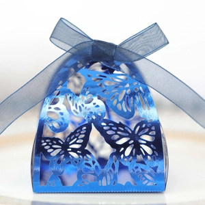 Macro detail of laser-cut butterfly wedding candy box with blue ribbon and metallic finish