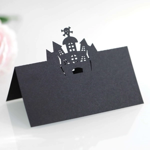 Detailed laser-cut Halloween place card featuring a black castle and skull silhouette design