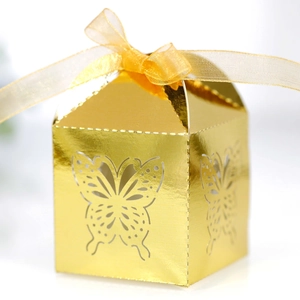 Detailed laser-cut butterfly pattern on golden gift box with elegant organza ribbon bow