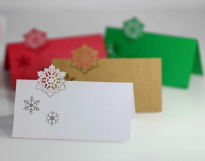 Macro detail of laser-cut snowflake Christmas place cards in multi-color cardstock
