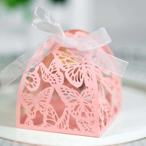 Detail of pink laser-cut butterfly gift box with elegant white ribbon and shimmer paper
