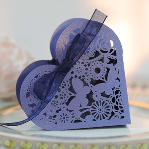 Detail of lavender heart-shaped laser cut wedding favors box with blue ribbon