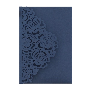 Detailed laser-cut rose pattern on dark blue wedding invitation card with textured paper