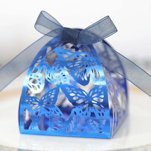 Macro view of blue laser-cut butterfly candy box with metallic finish and ribbon