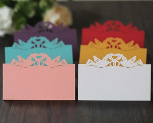 Detailed laser cut heart and bird wedding place cards in various vibrant paper colors