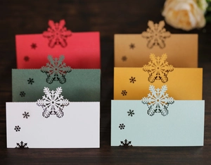 Détail des marque-places colorés découpés au laser avec flocons sur table en bois