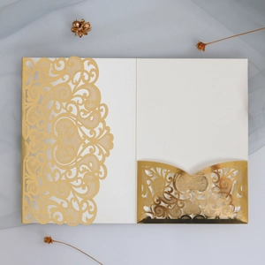 Elegant laser cut white and gold wedding invitation with intricate floral hollow design