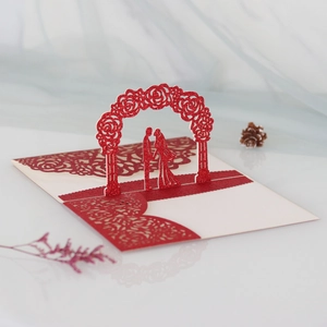 Detail of red glitter laser cut 3D pop-up wedding card with rose arch and couple