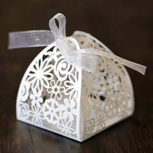 Detailed laser-cut floral pattern and heart design on white paper wedding favor gift box