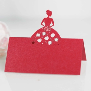 Macro detail of red laser-cut butterfly place card with elegant floral hollow patterns