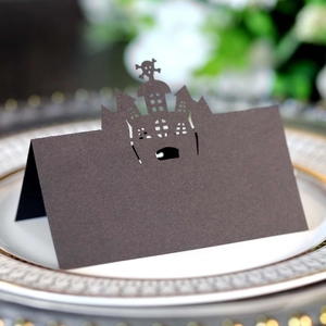 Macro detail of laser-cut black Halloween place card with castle silhouette on a plate