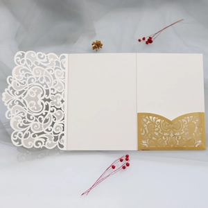 Detail of laser-cut gold lace pocket and intricate floral pattern on wedding invitation