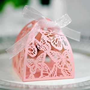 Pink laser cut wedding favor box with butterfly pattern and white organza ribbon