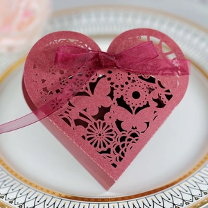 Detail of laser-cut heart candy box in burgundy with butterfly pattern and ribbon