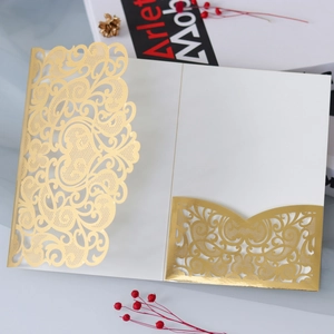 Close-up of golden laser-cut floral pattern and metallic gold texture on wedding invitation