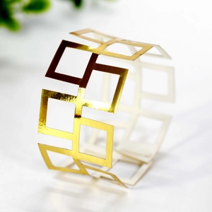 Close-up of geometric hollow golden napkin ring with a reflective polished finish