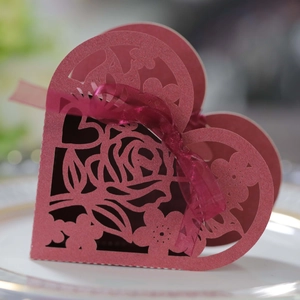 Vue macro d'une boîte cadeau cœur découpée au laser avec ruban rouge sur porcelaine