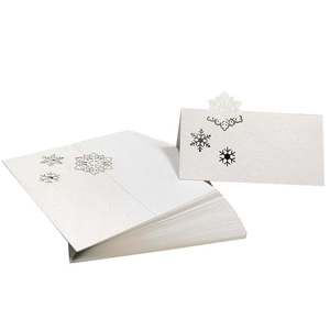 Detailed laser-cut white snowflake place card showing the intricate hollow engraving process