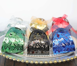 Detail of laser-cut butterfly gift boxes with organza ribbons in various metallic colors