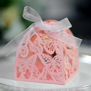 Detail showing pink laser-cut butterfly hollow pattern on gift box with white silk ribbon