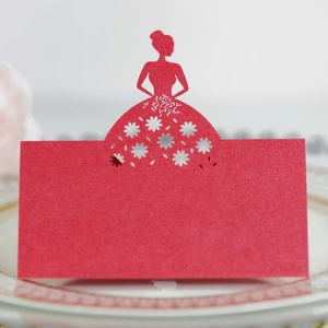Macro detail of laser-cut red paper place card with elegant silhouette for wedding table