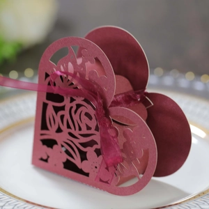 Détail de la boîte de mariage coeur bordeaux avec motifs de roses découpés au laser