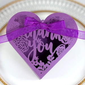 Detail of laser-cut Thank You purple heart gift box with elegant satin ribbon bow